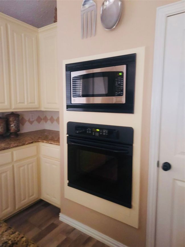 Kitchen has beautiful wall mounted appliances and ample cabinet space. | Image 10