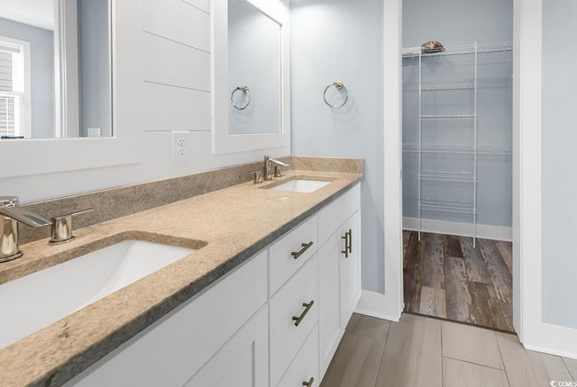 Full bathroom featuring double vanity, a spacious closet, and wood finished floors | Image 28