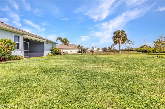View of back yard with a screened patio and fence | Image 47