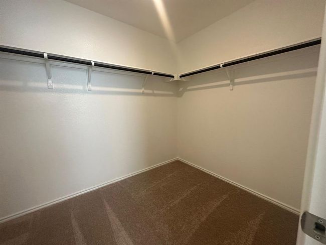 Spacious closet with dark colored carpet | Image 29