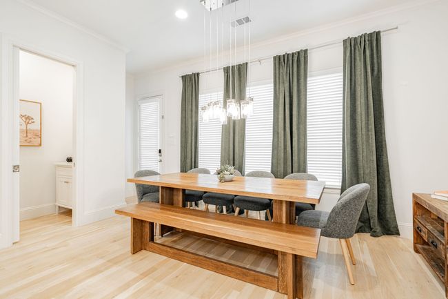 Dining room featuring crown molding, light wood finished floors, and beautiful lighting. | Image 13