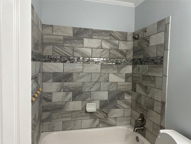 Full bath with toilet, shower / bathing tub combination, and ornamental molding | Image 8