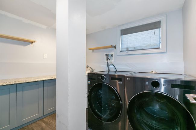 Clothes washing area with wood finished floors and separate washer and dryer | Image 28