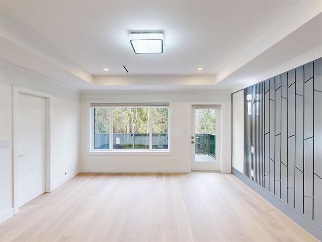 Empty room with a tray ceiling, light wood-type flooring, and recessed lighting | Image 28