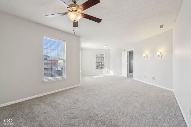 carpeted empty room featuring a textured ceiling, ceiling fan, and baseboards | Image 39