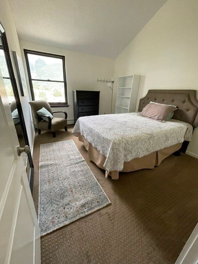 Carpeted bedroom featuring a textured ceiling and lofted ceiling | Image 5