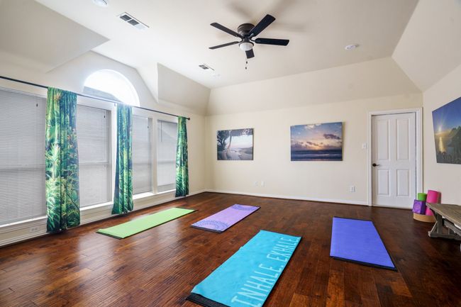 Spacious Bonus Room, lofted ceiling, wood flooring, baseboards, arched walkways, ceiling fan, built in cabinets with desk | Image 15