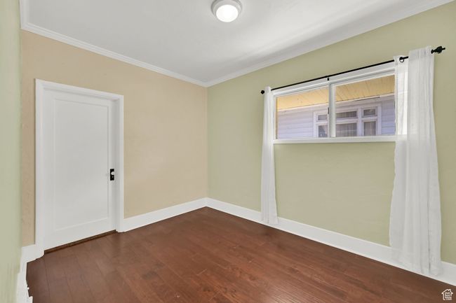 Unfurnished room with baseboards, crown molding, and dark wood-style floors | Image 14