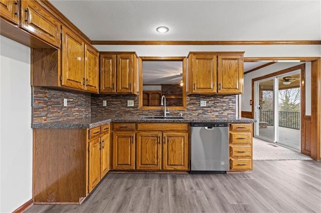 Kitchen with light hardwood / wood-style floors, stainless steel dishwasher, crown molding, and sink | Image 16