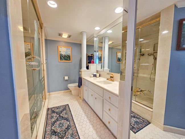 Full bathroom with crown molding, visible vents, vanity, toilet, and a stall shower | Image 25