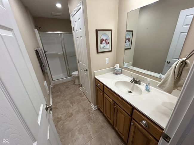full bathroom with toilet, vanity, stone finish floor, and a stall shower | Image 11