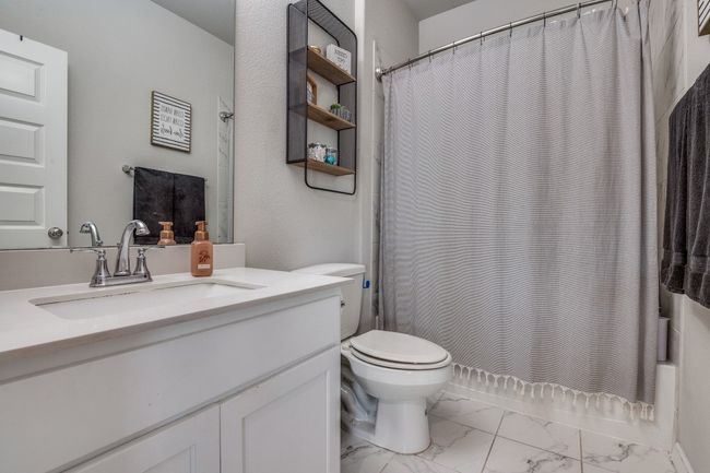 Full bath with marble finish floors, vanity, and shower / bath combo | Image 23