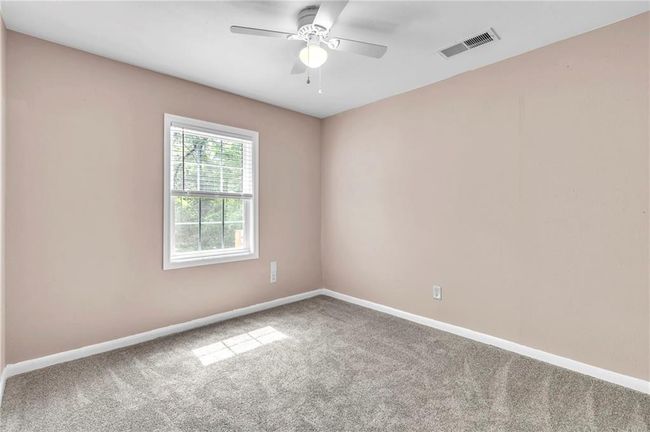 Empty room featuring baseboards, a ceiling fan, visible vents, and carpet | Image 28