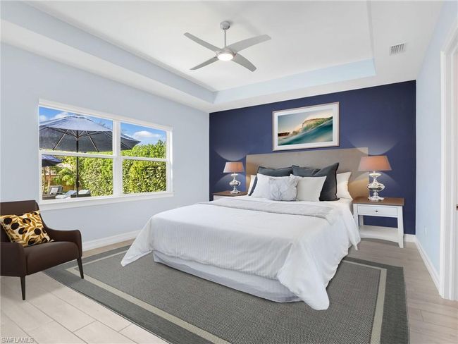 Bedroom featuring ceiling fan, light hardwood / wood-style floors, and a raised ceiling | Image 19