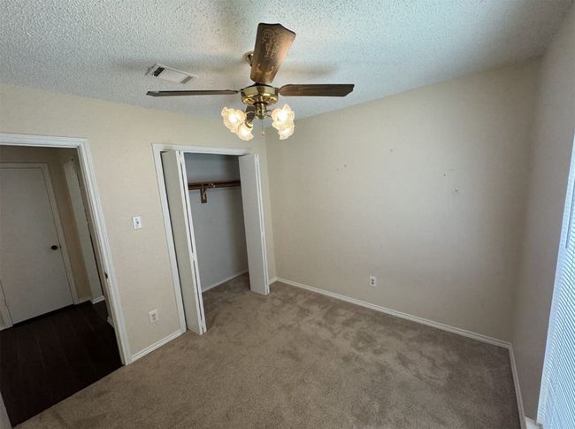 Unfurnished bedroom with a closet, a textured ceiling, ceiling fan, and carpet floors | Image 20