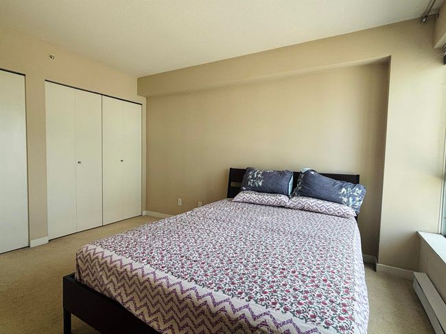 Bedroom with light colored carpet, a baseboard radiator, and baseboards | Image 8