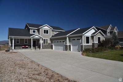 Craftsman house featuring a front yard, a garage, and covered porch | Image 1