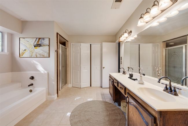 Full bathroom featuring double vanity, a shower stall, tile patterned floors, and a garden tub | Image 7