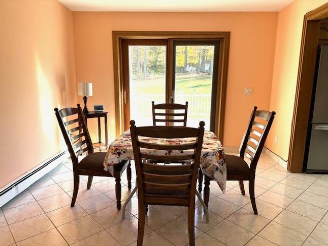 Dining room with baseboard heating and light tile patterned floors | Image 16