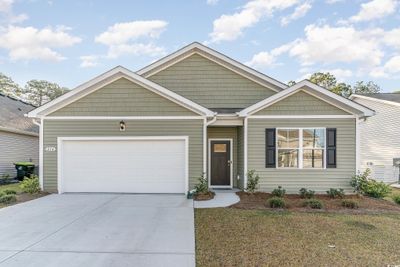 View of front of home with a front lawn and a garage | Image 1