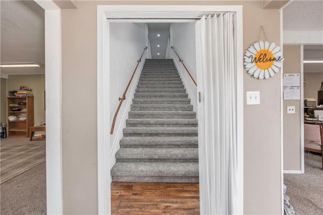 Staircase with a textured ceiling and carpet | Image 25