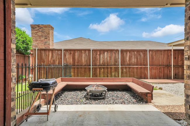 Fenced backyard featuring an outdoor fire pit, area for grilling, and a patio | Image 26