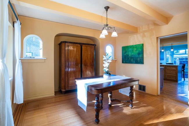 Entryway with light wood-style floors, visible vents, arched walkways, and beamed ceiling | Image 7