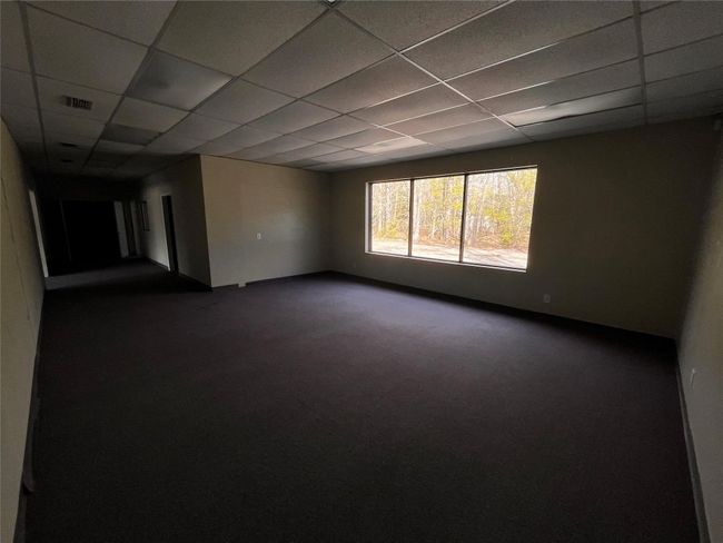 Unfurnished room with dark colored carpet, visible vents, and a drop ceiling | Image 11