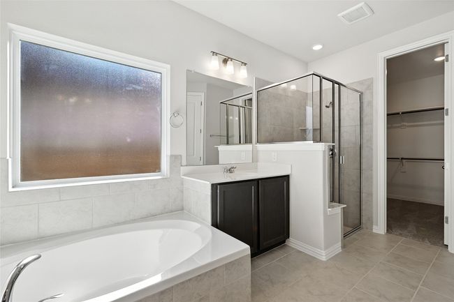 Full bath featuring a shower stall, a bath, vanity, and a spacious closet | Image 16