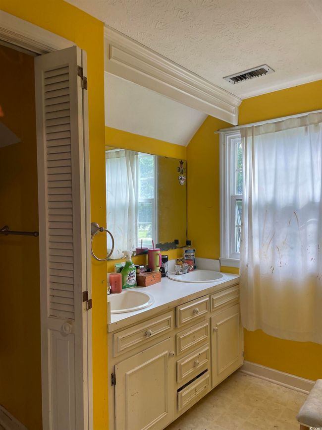 Full bath with double vanity, lofted ceiling, healthy amount of natural light, a textured ceiling, and a closet | Image 31
