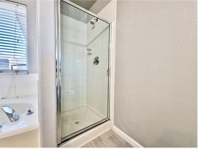 Full bathroom with a textured wall, a stall shower, and a garden tub | Image 17