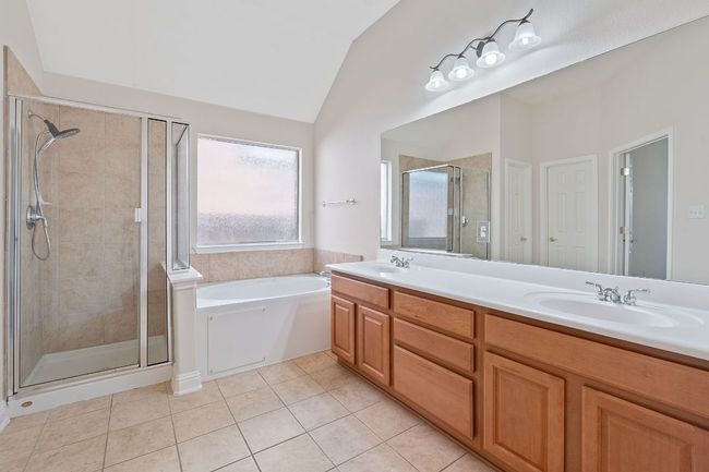 Full bathroom with tile patterned flooring, a sink, vaulted ceiling, and a shower stall | Image 23