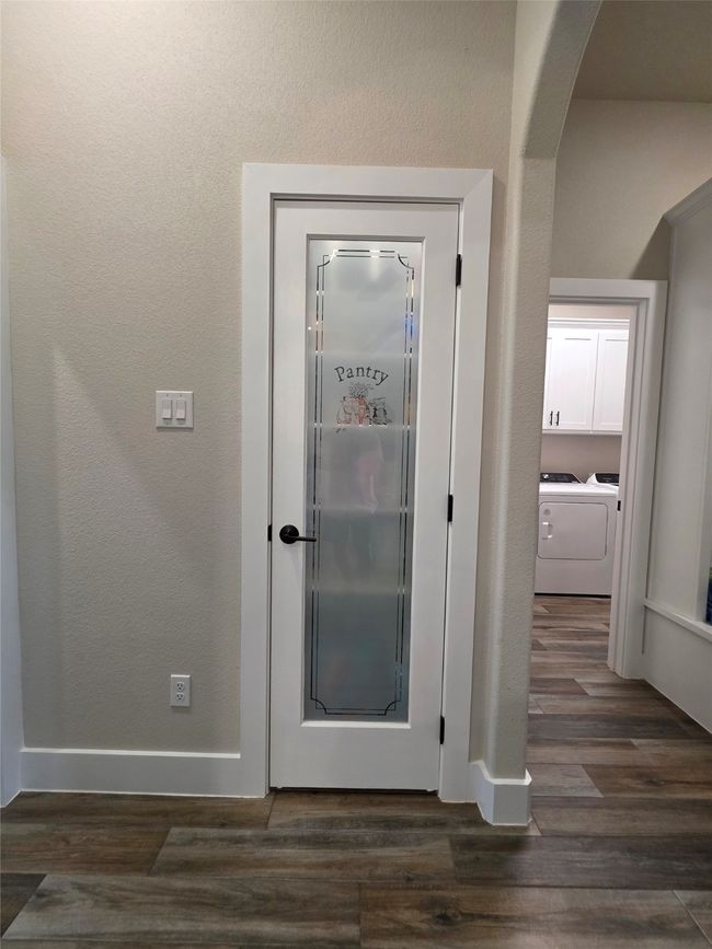 Detailed view of separate washer and dryer, wood finished floors, arched walkways, and a textured wall | Image 15
