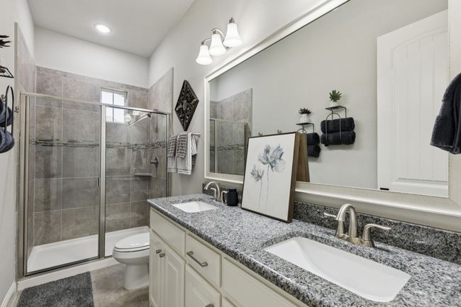 Full bath with double vanity, a stall shower, and tile patterned flooring | Image 25