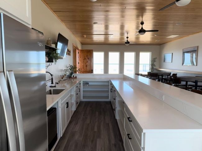 Kitchen featuring white cabinets, light countertops, and freestanding refrigerator | Image 26