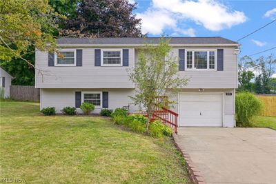 Bi-level home with a garage and a front lawn | Image 1