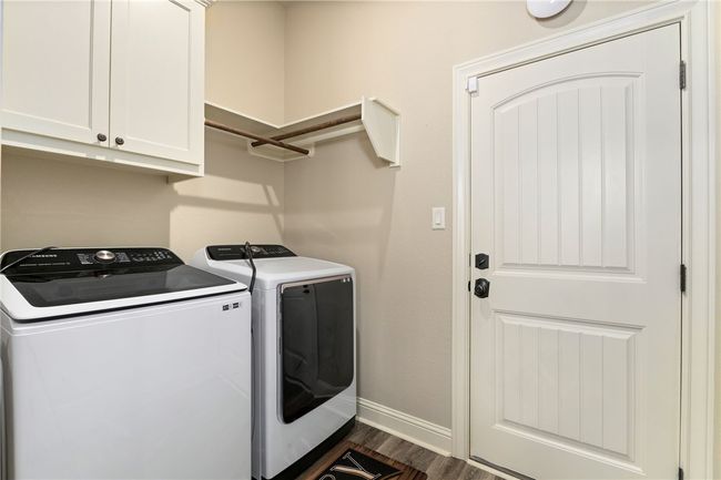 Washroom featuring separate The laundry room includes built-in cabinetry, shelving, hanging racks, and washer connections. | Image 25