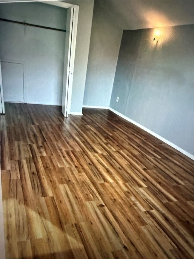 Unfurnished bedroom with dark wood-style floors and baseboards | Image 22