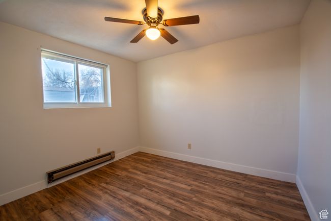 Spare room with dark hardwood / wood-style flooring, baseboard heating, and ceiling fan | Image 12