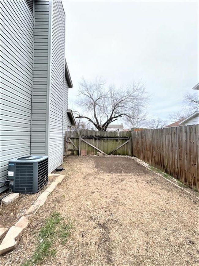 Fenced backyard featuring cooling unit | Image 13