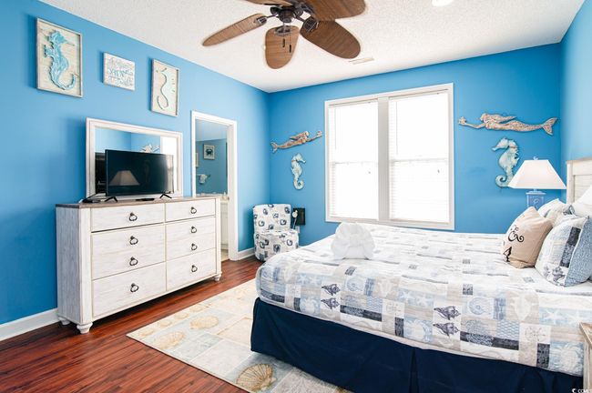 Bedroom featuring dark wood-type flooring, baseboards, ceiling fan, and a textured ceiling | Image 29