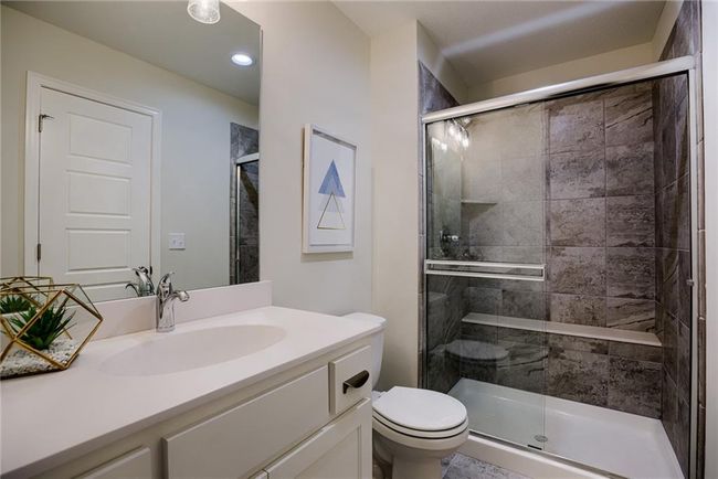Bathroom featuring a shower with door, tile floors, toilet, and large vanity | Image 43