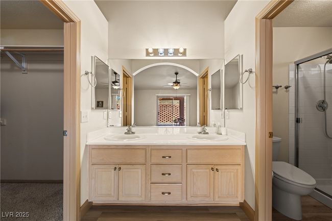 Bathroom with a shower stall, double vanity, ceiling fan, and wood finished floors | Image 33