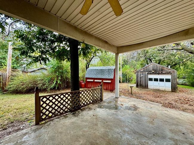 View of patio featuring an outdoor structure, a garage, ceiling fan, and driveway | Image 24