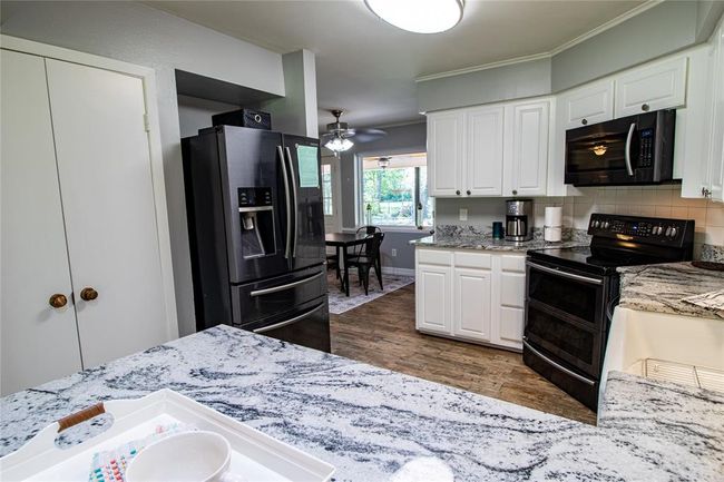 View of kitchen from dining area. Breakfast area with large window for viewing the back yard is just past the refrigerator. | Image 34