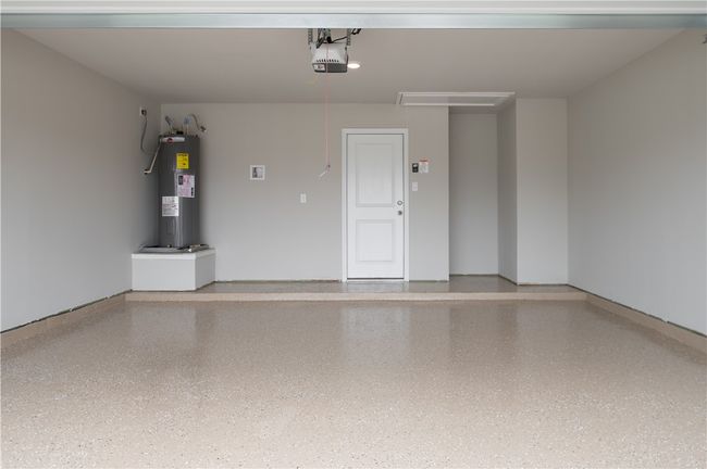 Garage featuring a garage door opener and electric water heater | Image 21