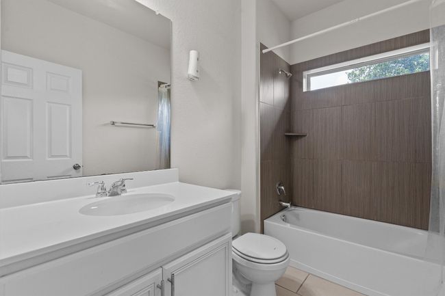 Full bath with vanity, shower / tub combo, toilet, and tile patterned flooring | Image 24