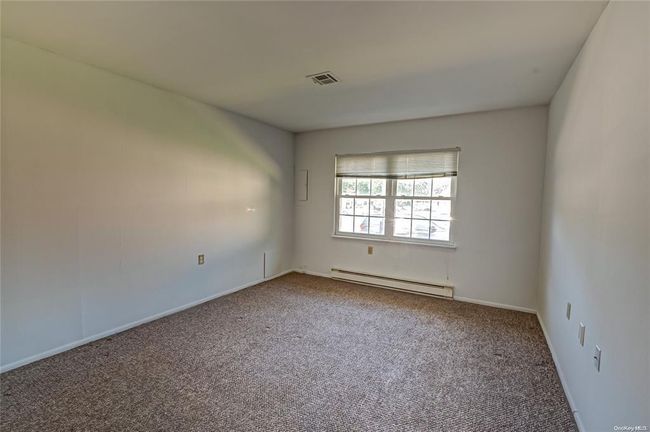 Carpeted empty room with a baseboard radiator | Image 5