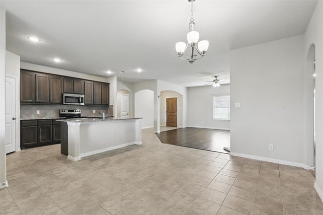 Kitchen with appliances with stainless steel finishes, arched walkways, ceiling fan, dark brown cabinetry, and recessed lighting | Image 7