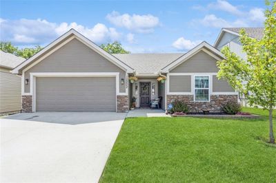 Ranch home with front yard and a garage | Image 1